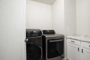 Laundry room featuring cabinets and washing machine and clothes dryer