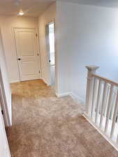 Hallway featuring carpet flooring, an upstairs landing, baseboards, and recessed lighting