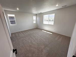 Unfurnished room featuring light carpet, baseboards, a textured ceiling, and recessed lighting