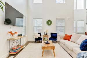 Living room with a high ceiling and wood-type flooring