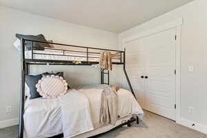 Carpeted bedroom featuring a closet