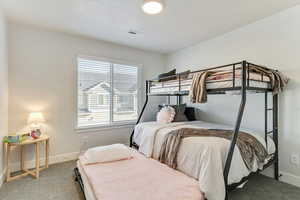 Bedroom featuring carpet and a textured ceiling