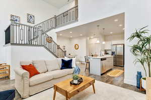 Living room featuring a towering ceiling, wood-type flooring, and sink