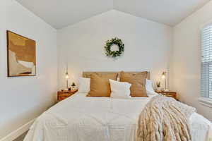 Bedroom with lofted ceiling and carpet floors