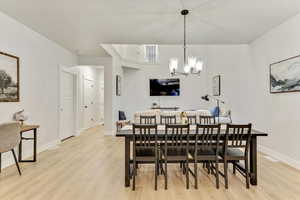 Dining space featuring light hardwood / wood-style flooring and a notable chandelier