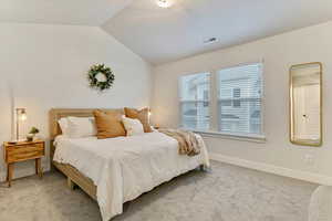 Carpeted bedroom featuring vaulted ceiling