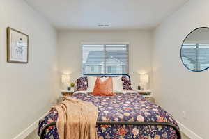 Carpeted bedroom featuring multiple windows