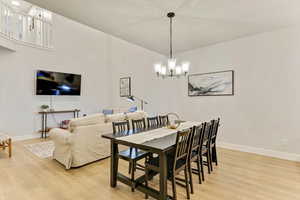 Dining space featuring a notable chandelier and light hardwood / wood-style flooring