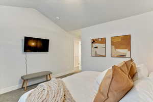 Bedroom featuring vaulted ceiling and carpet