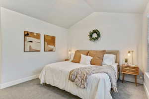 Carpeted bedroom with vaulted ceiling