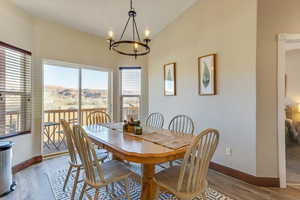 Dining room with hardwood / wood-style flooring, a mountain view, and a notable chandelier