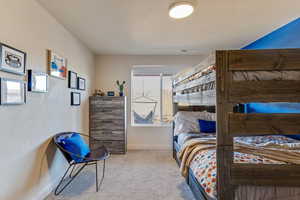 Bedroom featuring light carpet