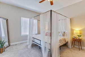 Carpeted bedroom featuring ceiling fan