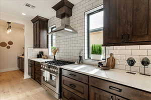 Kitchen with light hardwood / wood-style flooring, hanging light fixtures, a wealth of natural light, and stainless steel range with gas stovetop