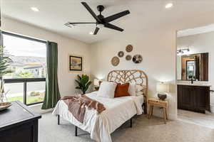 Bedroom with connected bathroom, a mountain view, light colored carpet, and sink