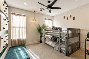 Carpeted bedroom featuring ceiling fan