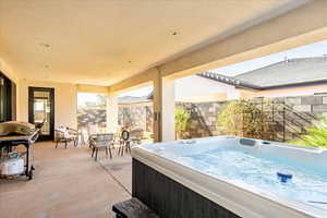 View of patio / terrace with a hot tub and a grill