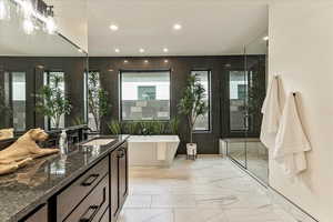 Bathroom featuring plus walk in shower and vanity