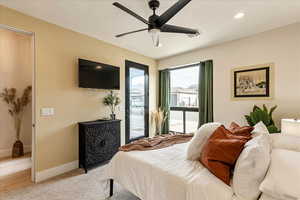 Bedroom with light colored carpet, access to exterior, and ceiling fan