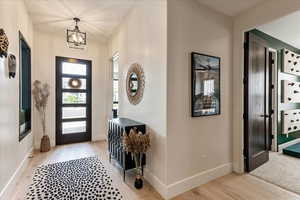 Entrance foyer featuring a notable chandelier and light hardwood / wood-style floors