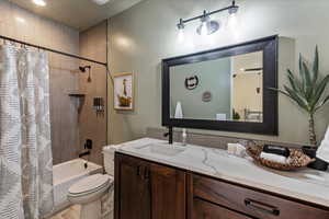 Full bathroom featuring shower / bath combo, vanity, and toilet