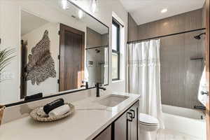 Full bathroom featuring shower / tub combo with curtain, vanity, and toilet