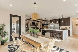 Dining room featuring a stone fireplace and light hardwood / wood-style flooring