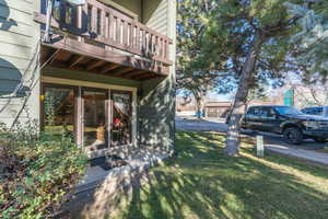 View of side of property with a balcony and a yard