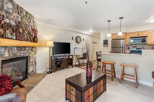 Carpeted living room with a stone fireplace