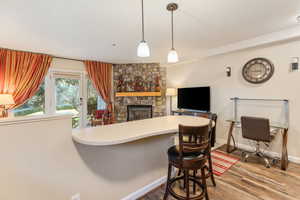 Interior space featuring a fireplace, hardwood / wood-style floors, and hanging light fixtures