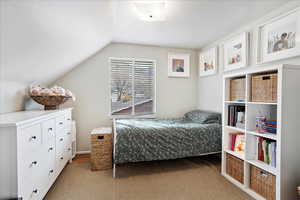 Carpeted bedroom with lofted ceiling