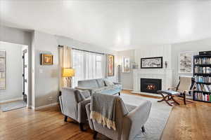 Living room with a tiled fireplace and light hardwood floors