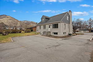 View of home's exterior featuring cooling unit, a yard, and a mountain view