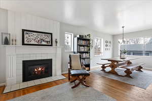 Dining space with a chandelier, hardwood floors, and a fireplace