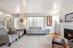 Living room featuring a tiled fireplace and light hardwood floors