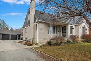 View of front of property with an outbuilding, a garage, a front yard, and covered porch