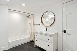 Bathroom with shower / bathtub combination with curtain and vanity