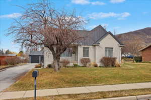 View of front of property featuring a garage, a mountain view, and a front yard