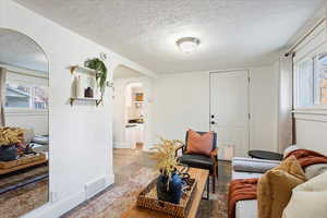 Living room with light wood-type flooring and a textured ceiling