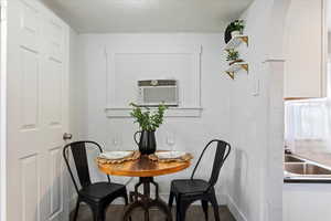 Dining room featuring a textured ceiling, a wall mounted air conditioner, and sink