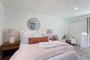 Bedroom featuring a textured ceiling and hardwood / wood-style floors