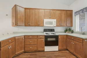 Kitchen featuring hardwood / wood-style flooring, lofted ceiling, sink, and electric range