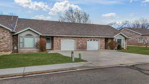 Ranch-style home with a garage, a mountain view, and a front yard