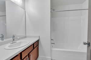 Bathroom featuring vanity and washtub / shower combination