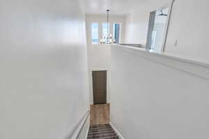 Stairway with a chandelier and hardwood / wood-style floors