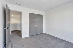 Unfurnished bedroom with a closet and carpet