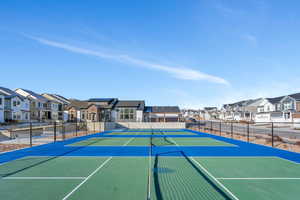 View of tennis court featuring basketball hoop