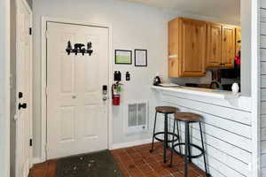 Interior space featuring dark tile patterned floors and a kitchen bar