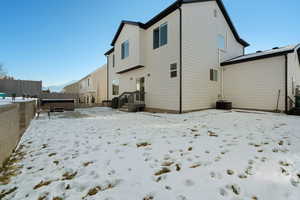 Snow covered house with a jacuzzi and central air condition unit