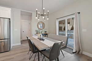 Dining area with an inviting chandelier and light hardwood / wood-style flooring